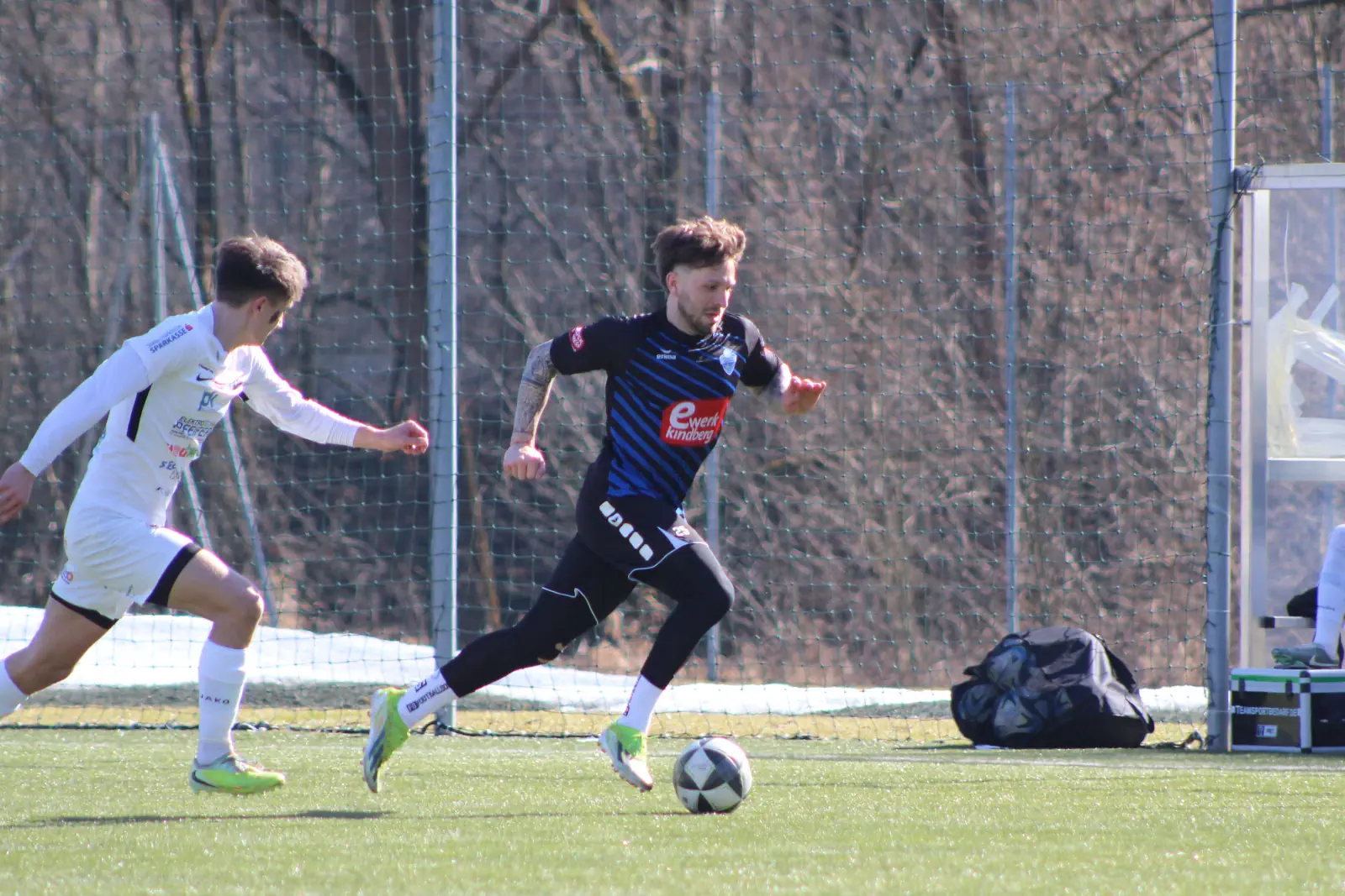 Zwei Fußballer laufen einem Ball nach.