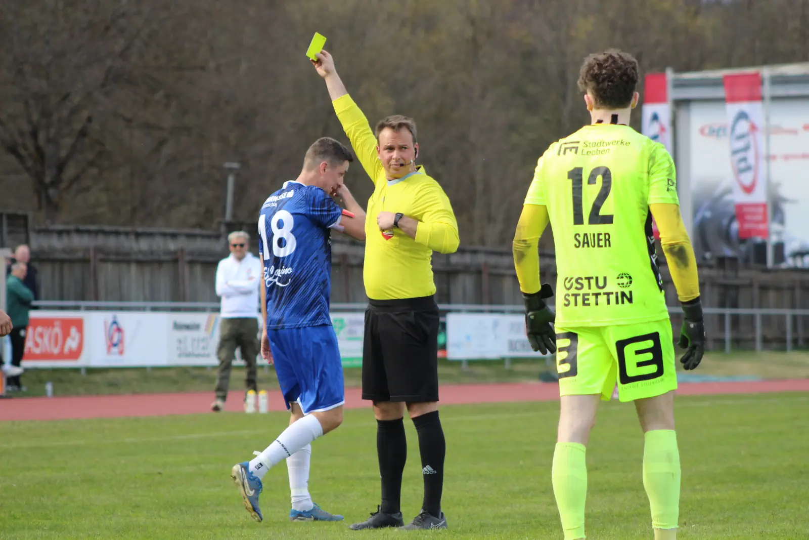 Ein Schiedsrichter zeigt die Gelbe Karte.