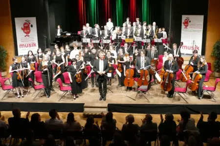 Musikorchester bei einem Konzertauftritts auf einer Bühne.