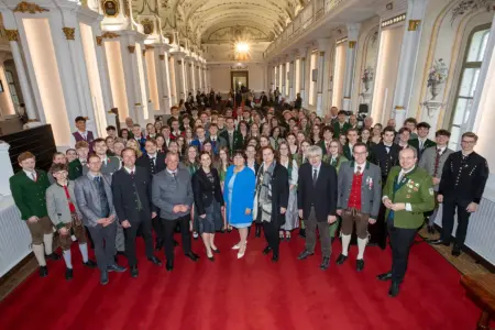Eine große Gruppe von Personen steht in einem Festsaal.