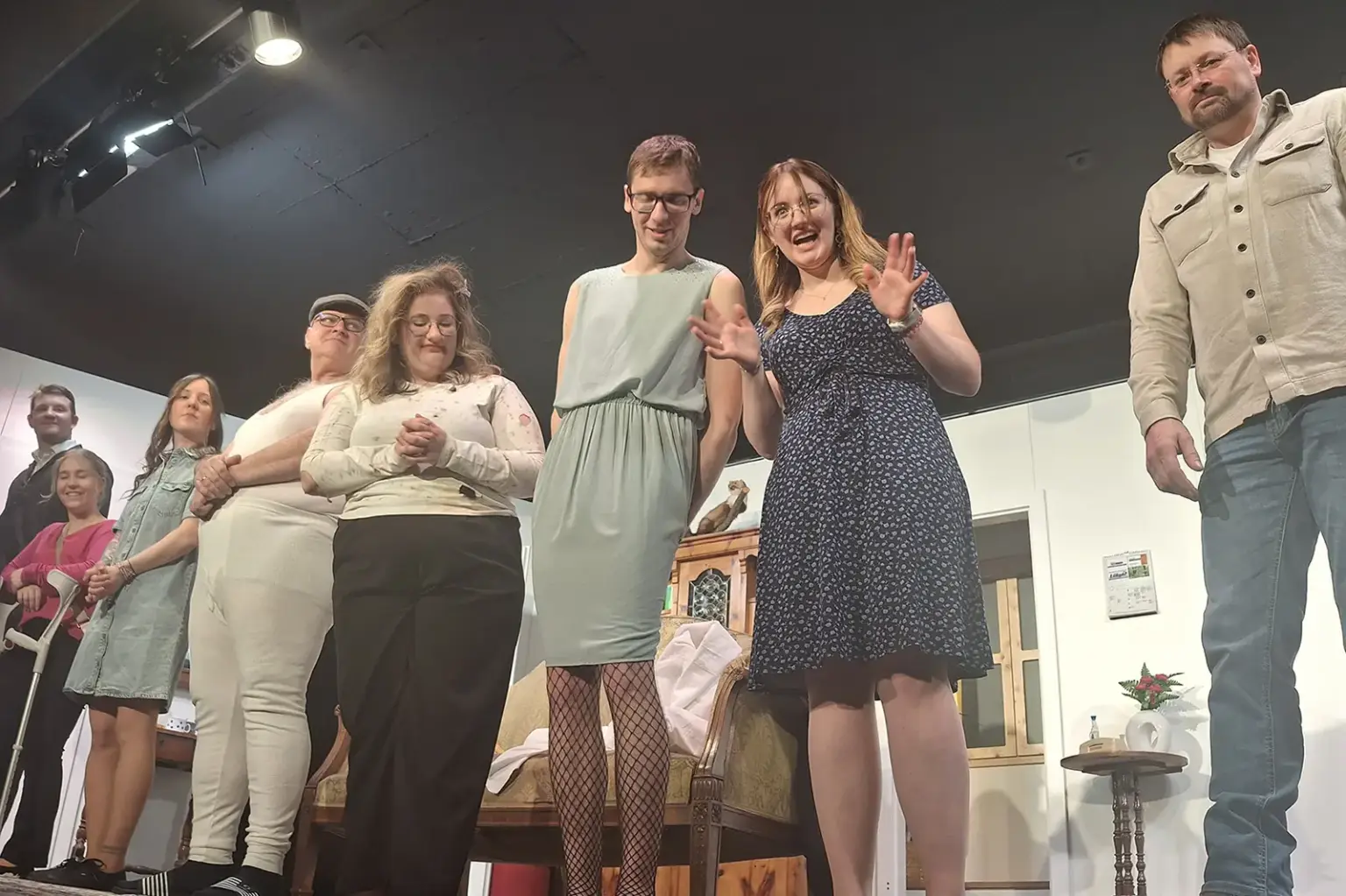 Ein Theatersensemble steht in Kostümen auf einer Bühne