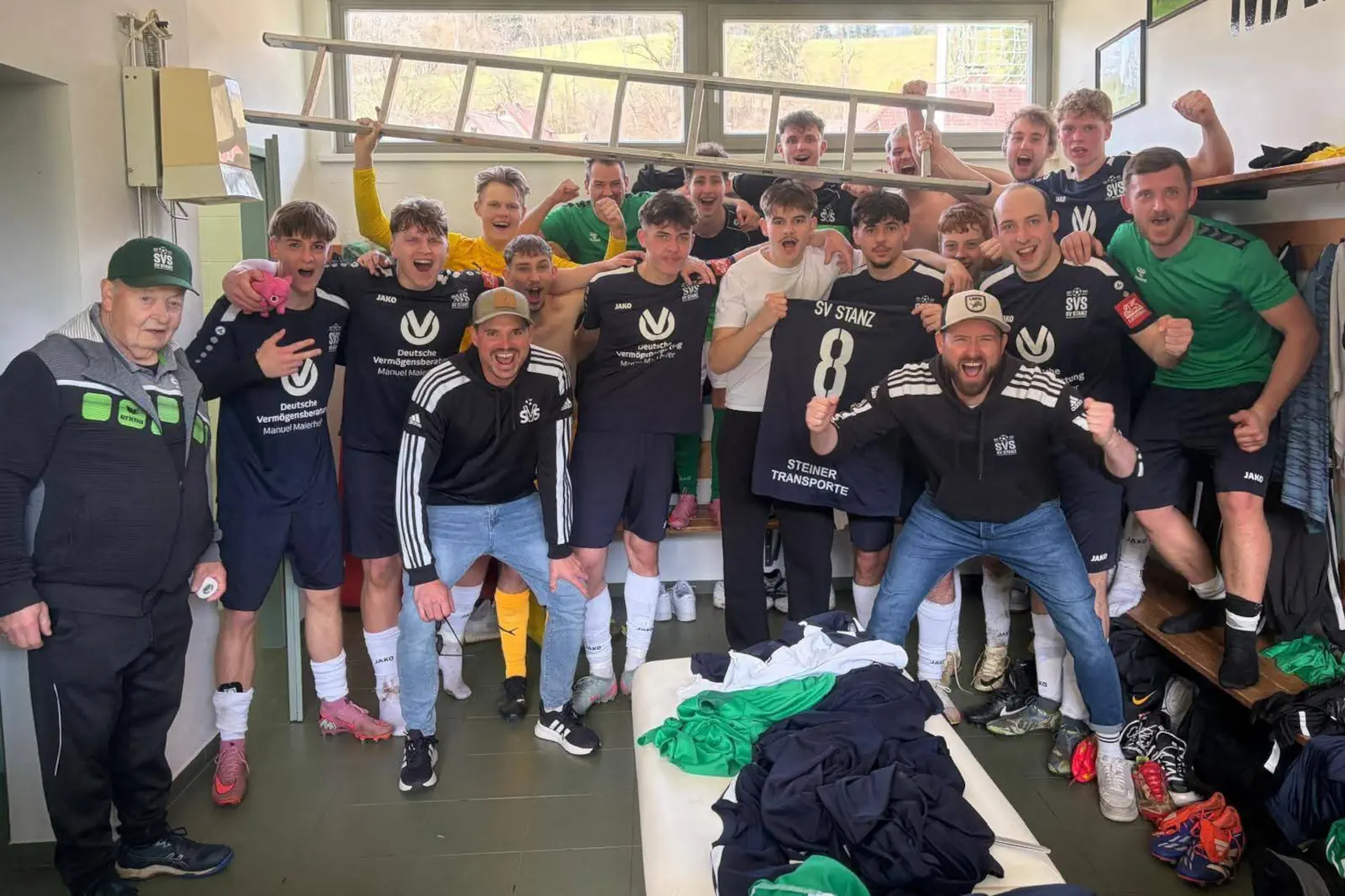 Fußballer jubeln in der Kabine.