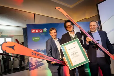 Drei Männer mit Schiern und einer Urkunde