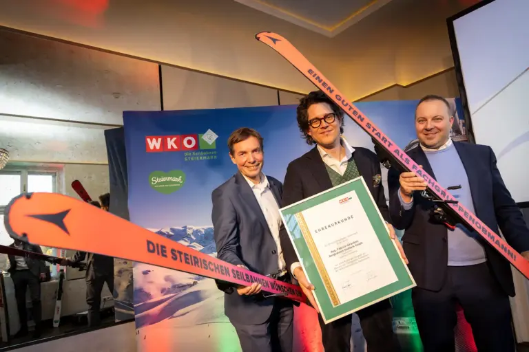 Drei Männer mit Schiern und einer Urkunde