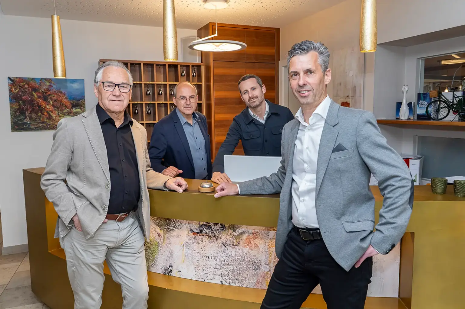 Vier Männer stehen an einer Hotelrezeption