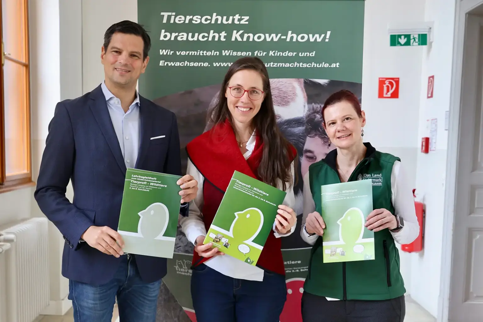 Ein Mann und zwei Frauen präsentieren ein Druckerzeugnis