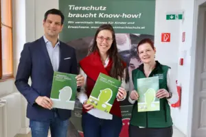 Ein Mann und zwei Frauen präsentieren ein Druckerzeugnis