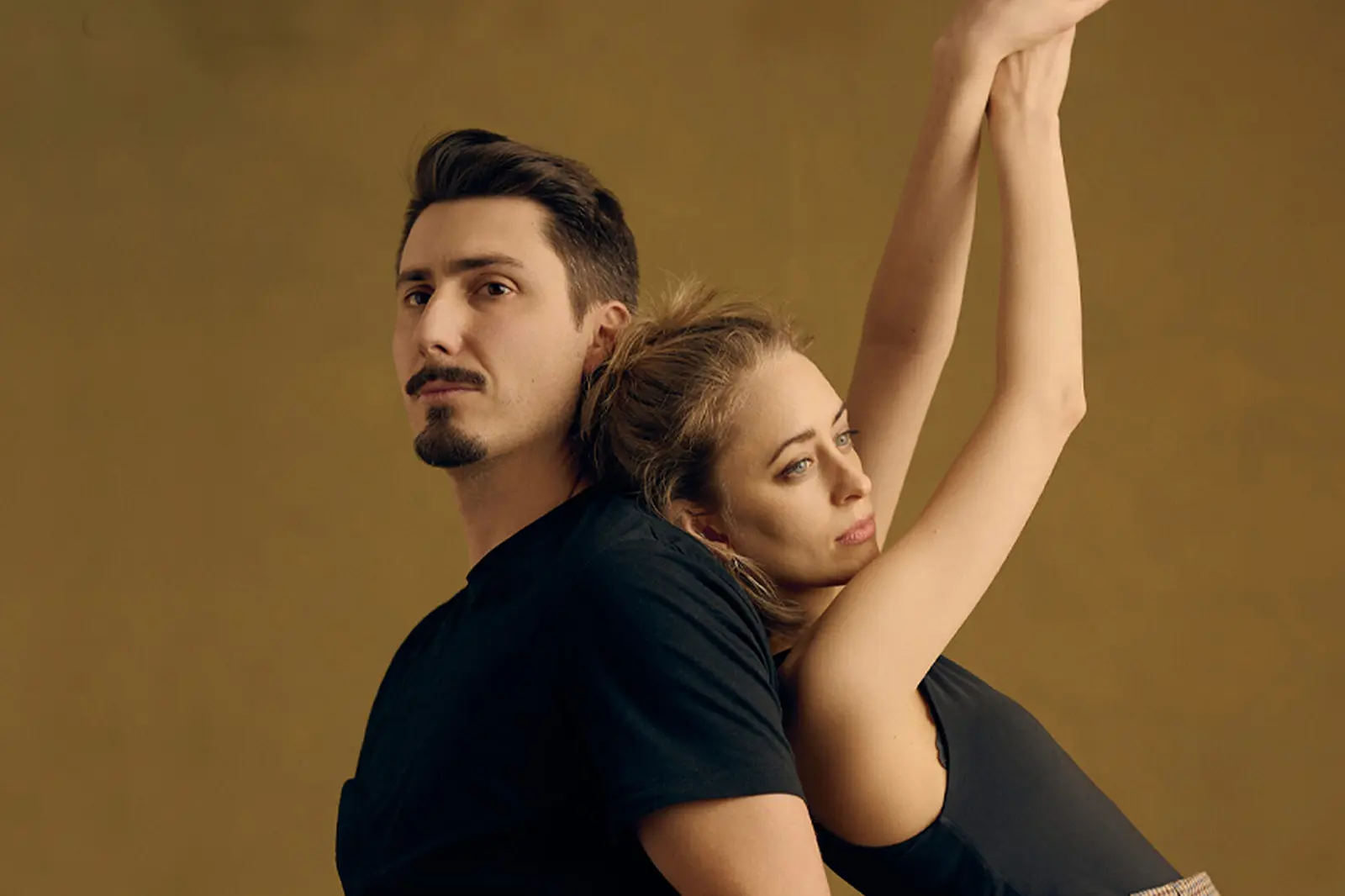 Ein Mann und eine Frau stehen vor einer braunen Wand