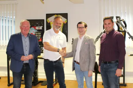 Vier Männer stehen in einem Raum mit Fitnessgeräten