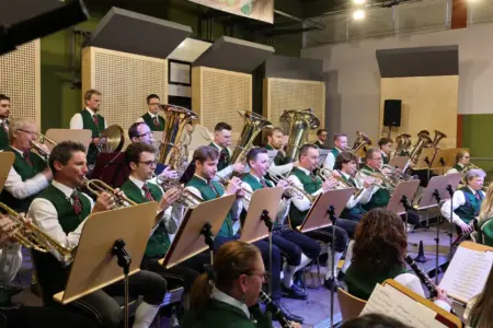 Eine Musikkapelle in Tracht spielt auf einer Bühne.