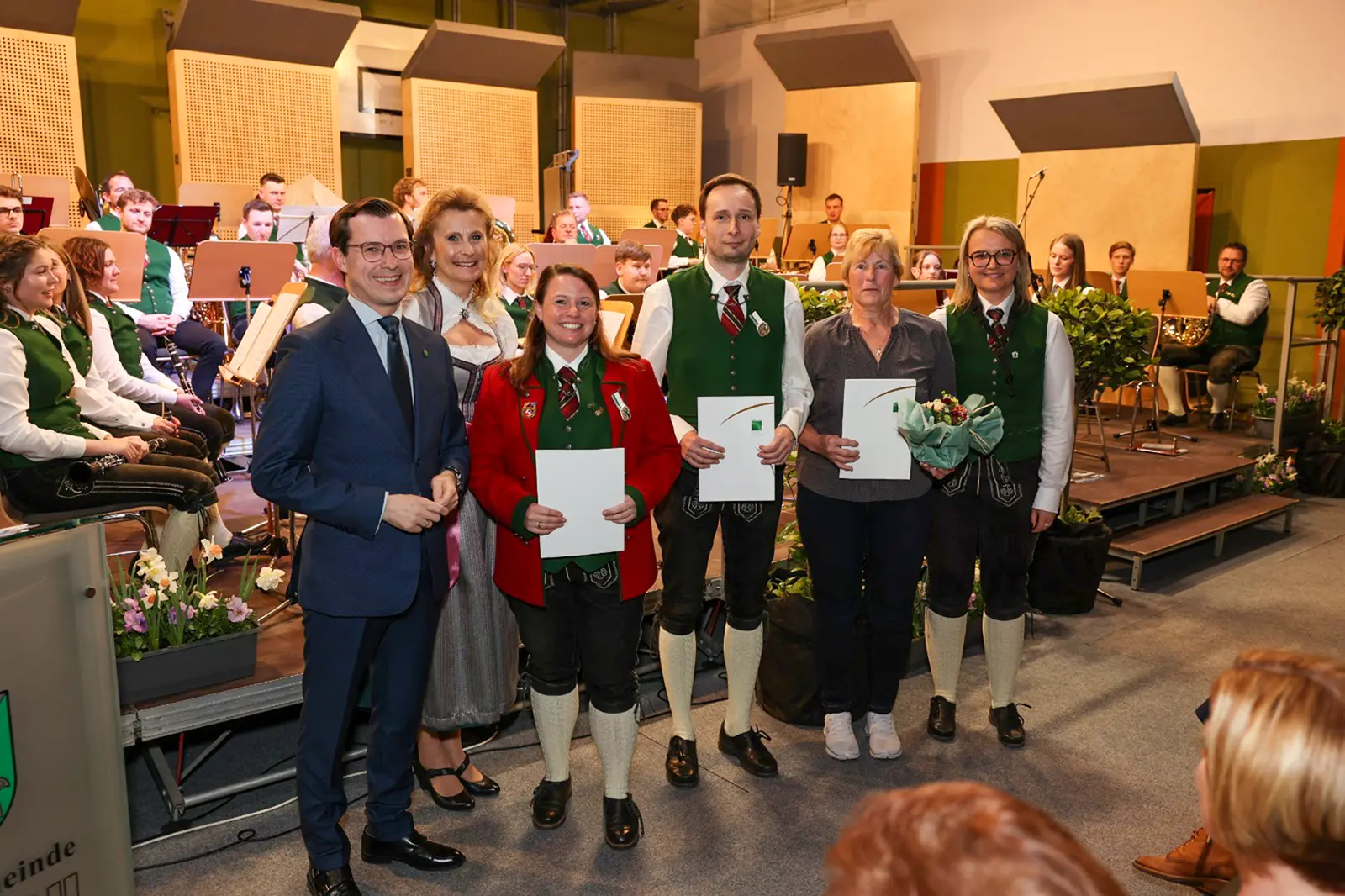 Sechs Personen mit Urkunden stehen vor einer Musikkapelle