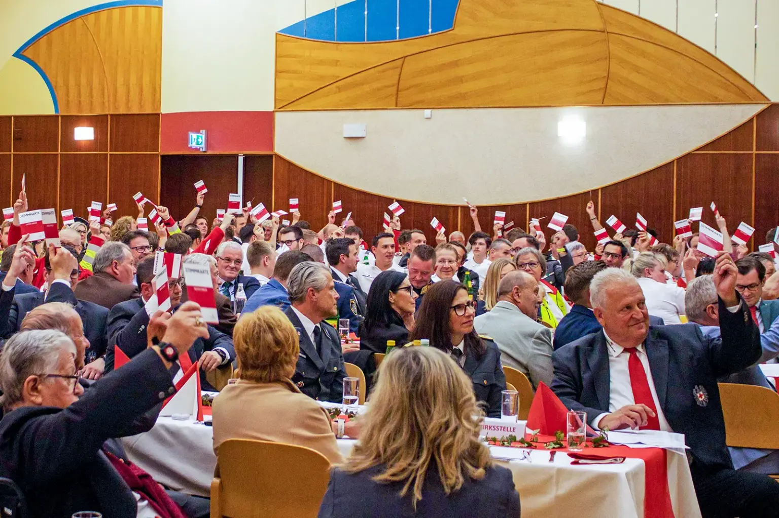 Neuer Bezirkschef beim Roten Kreuz Ein dicht besetzter Saal mit Delegierten, die Stimmkarten in die Höhe halten