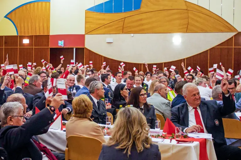 Neuer Bezirkschef beim Roten Kreuz Ein dicht besetzter Saal mit Delegierten, die Stimmkarten in die Höhe halten