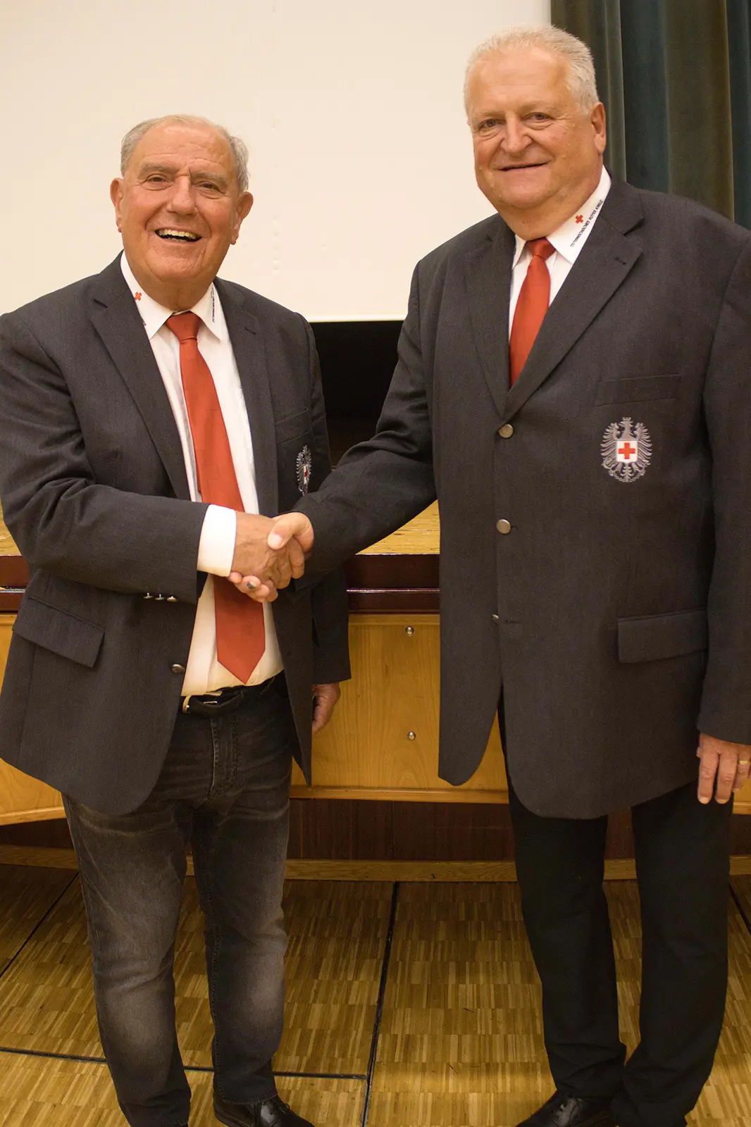 Zwei Männer in Anzügen geben sich die Hand.