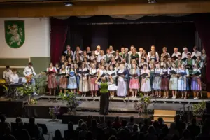 Stimmgewaltiger Abend in Birkfeld Ein großer gemischter Chor in Trachtenkleidung singt auf einer Bühne