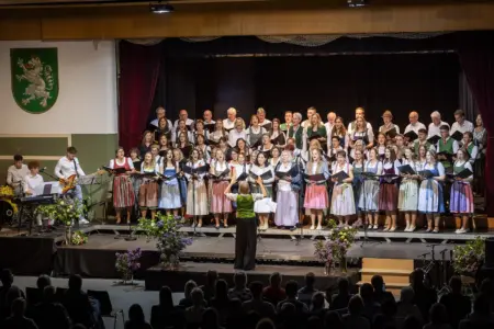 Stimmgewaltiger Abend in Birkfeld Ein großer gemischter Chor in Trachtenkleidung singt auf einer Bühne