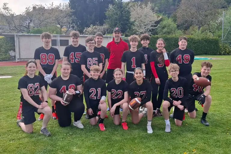 Jugendliche im Football-Dress und Bällen.