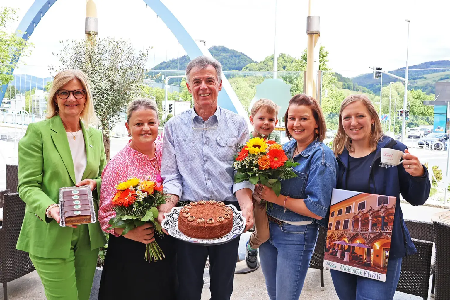 Brucker Konditorei feiert ihren 40er Vier Frauen, ein Mann und ein Kind halten Blumen und Mehlspeisen