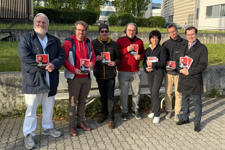 Eine Frau und sechs Männer mit Foldern der SPÖ in den Händen.
