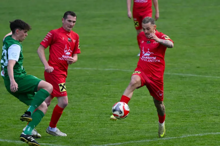 Ein Spieler in Rot ist in Ballbesitz.
