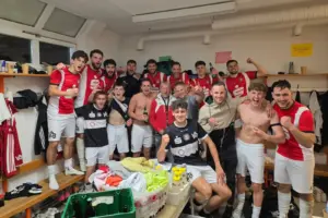 Fußballer feiern in der Kabine.