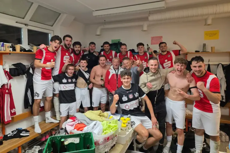 Fußballer feiern in der Kabine.