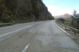 Eine schadhafte Straße mit Blick auf einen Berg