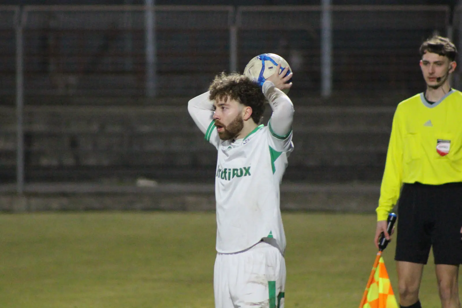Ein Fußballer hält einen Ball in den Händen.