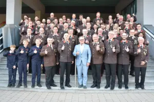 Eine große Gruppe von Personen in Uniform steht auf einer Treppe vor einem Haus
