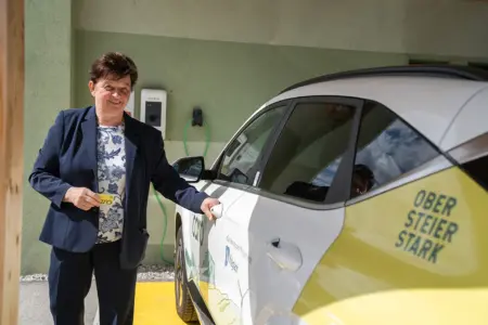Eine Frau mit einem Elektroauto.
