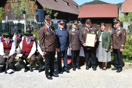 Eine Frau mit Feuerwehrmännern. Danemen sitzen ein paar Musikanten.