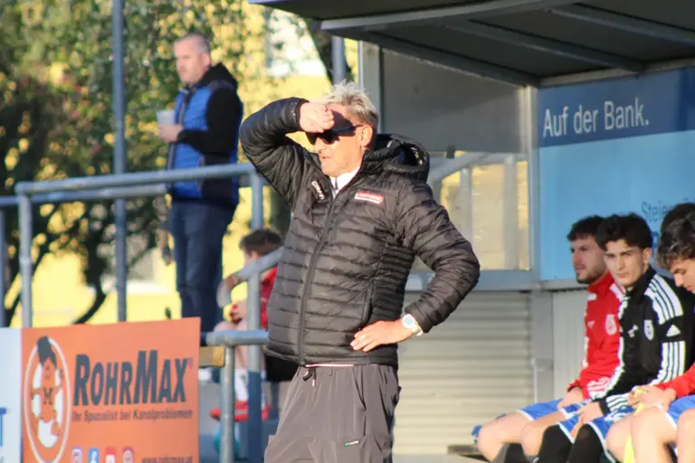 Ein Fußballtrainer wird von der Sonne geblendet