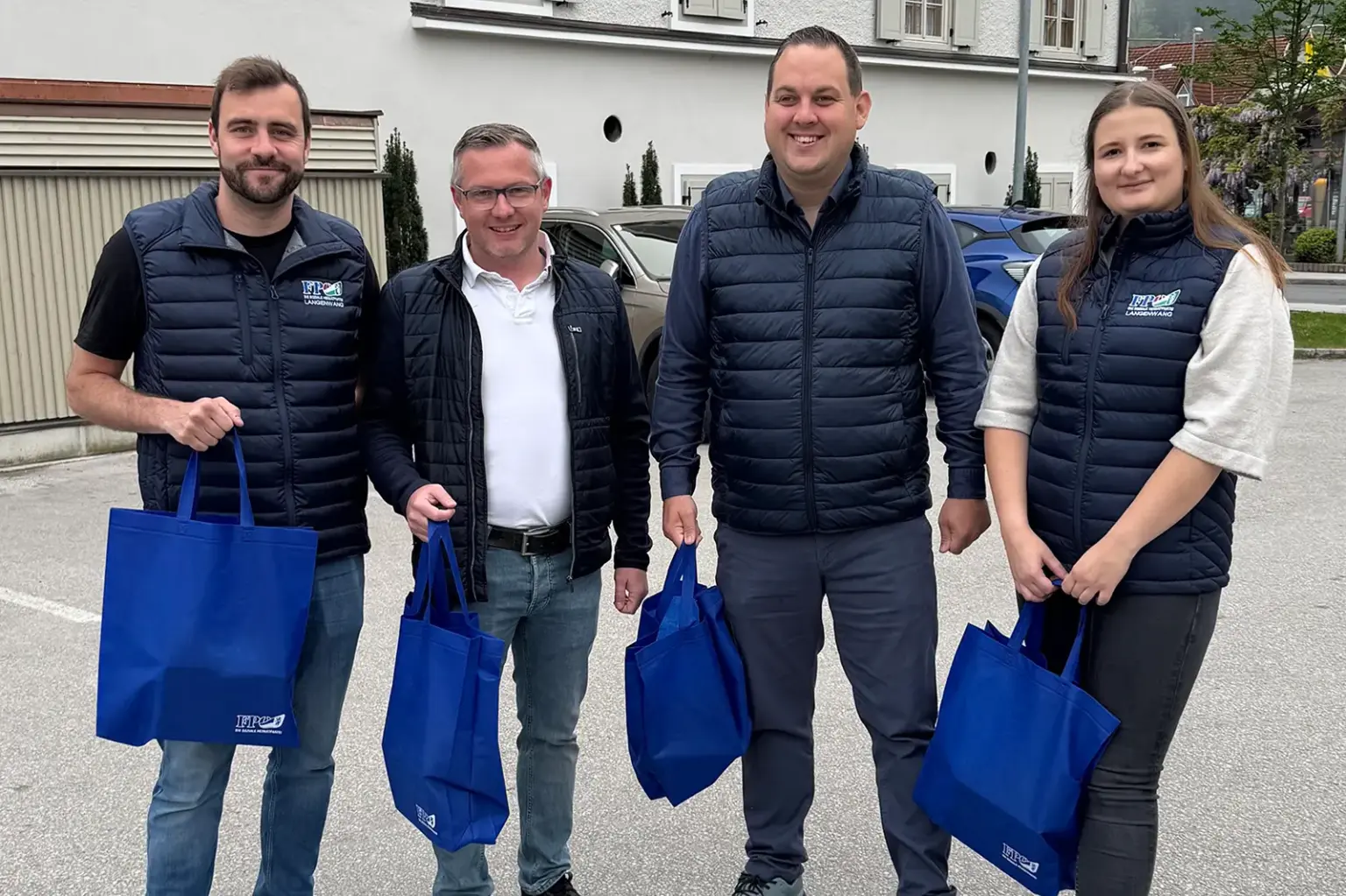Eine Frau und drei Männer mit blauen Taschen.