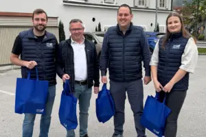 Eine Frau und drei Männer mit blauen Taschen.