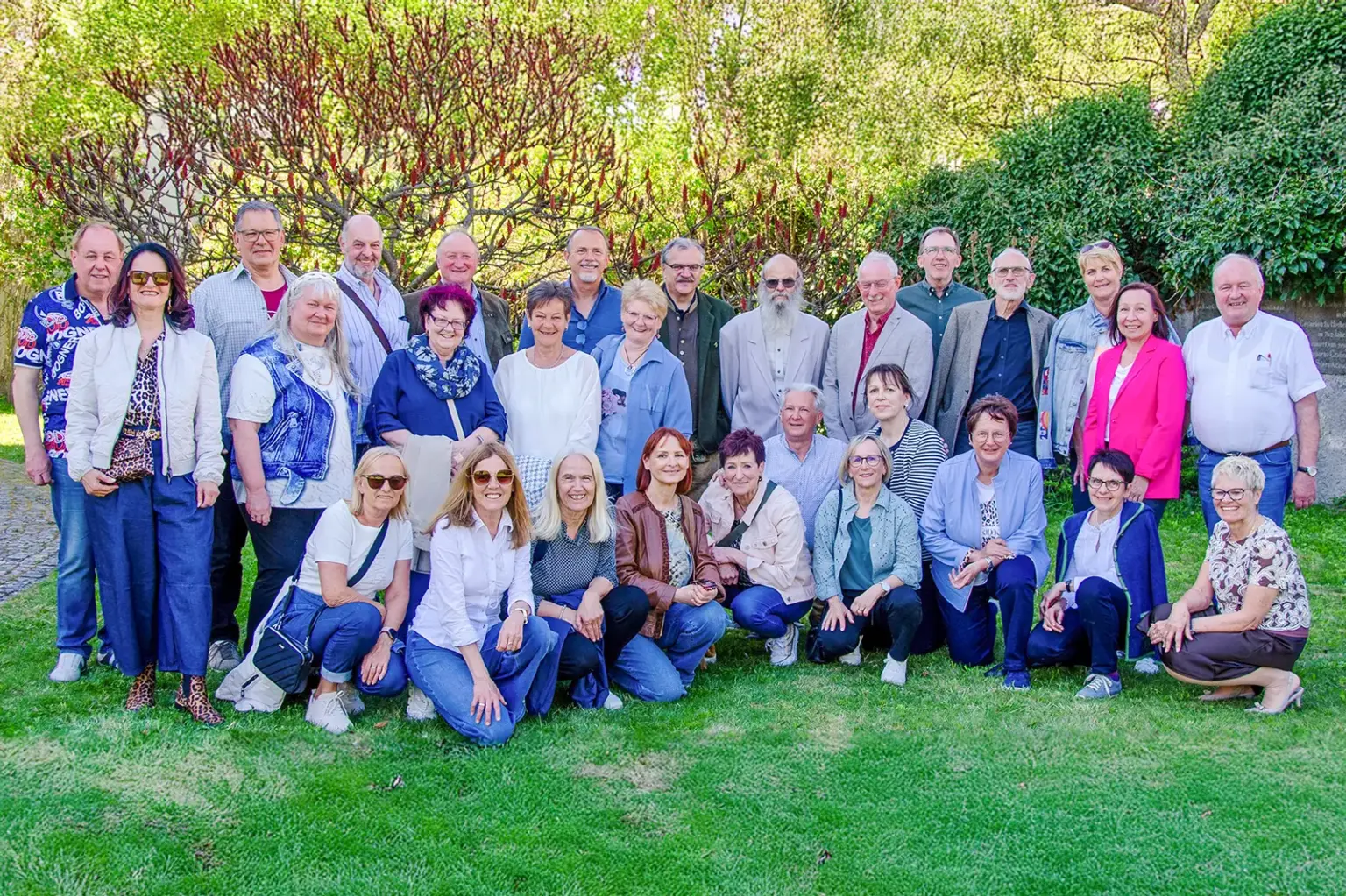 Klassentreffen nach 50 Jahren in Langenwang Eine große Gruppe älterer Menschen steht auf einer Wiese