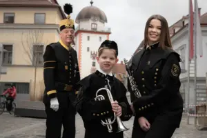 Ein Mann, ein kleiner Junge und eine junge Frau mit Musikinstrumenten in bergmännischer Tracht