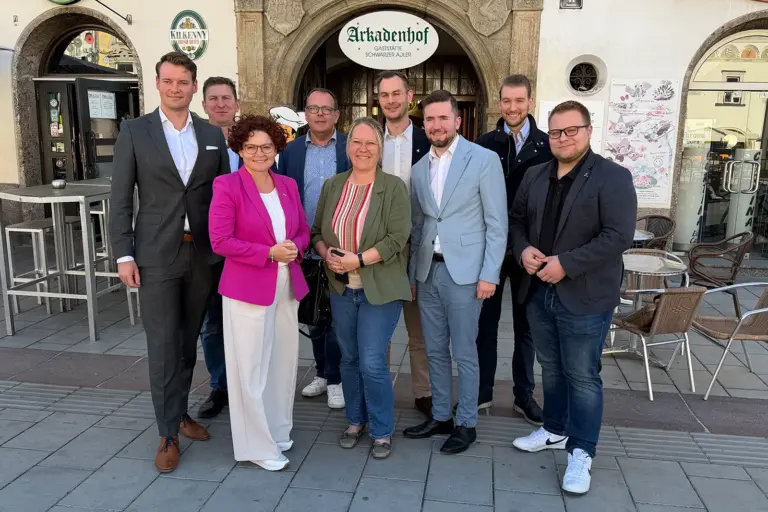 Eine Gruppe von Personen steht vor einem Hauseingang