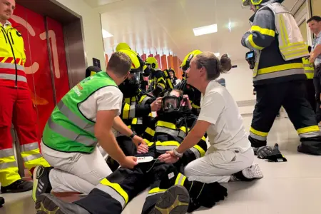 Vertreter mehrere Einsatzorganisationen agieren in einem Flur