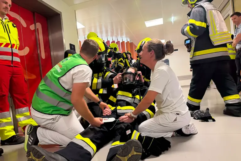 Vertreter mehrere Einsatzorganisationen agieren in einem Flur