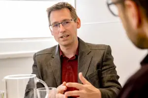 Ein Mann mit Brille spricht