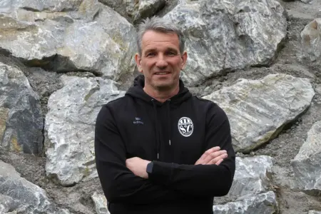 Krebs nicht mehr Parschlug-Trainer Ein Mann steht vor einer Steinwand.