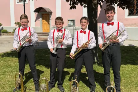 Preisgekrönte Musikjugend aus Mürzzuschlag Vier junge Burschen mit Trompeten stehen unter einem Baum