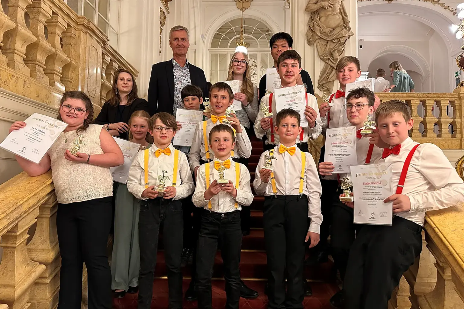 Preisträgerkonzert der Musikschule Mürzzuschlag Eine Gruppe von Kindern und Jugendlichen stehen mit einem Erwachsenen auf einer Treppe