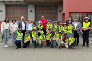 Kinder der Volksschule Niklasdorf präsentieren neue Trinkflaschen. Dahinter Erwachsene.