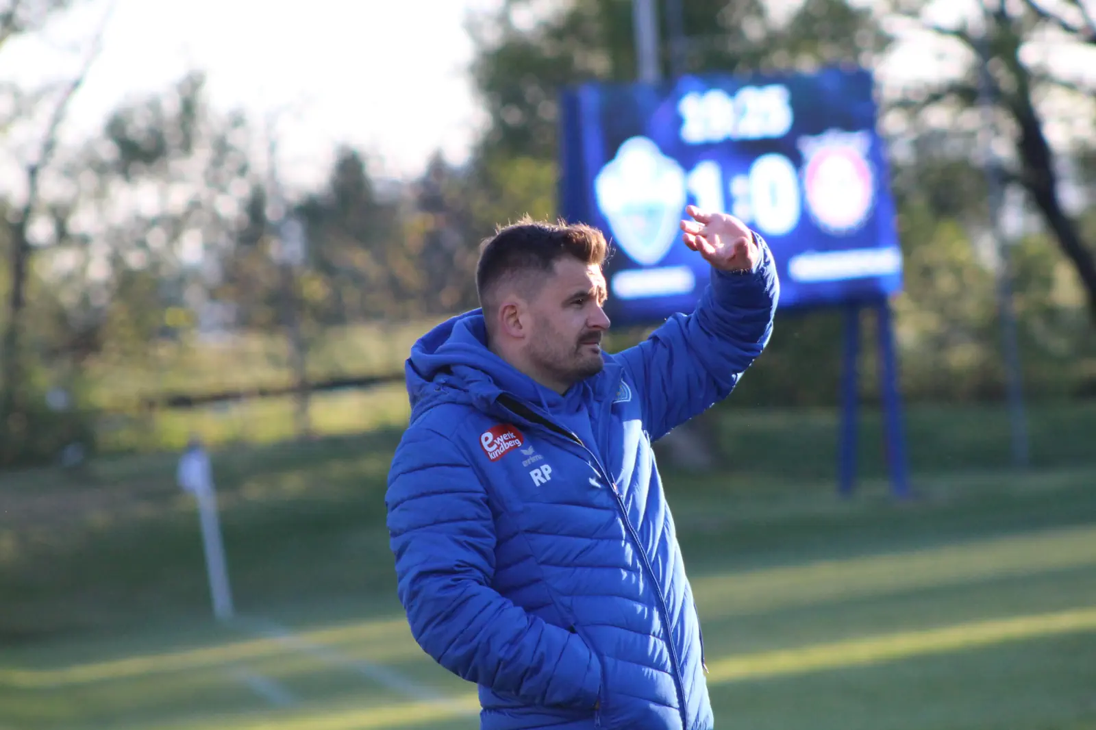 Ein Fußballtrainer mit gehobener Hand.