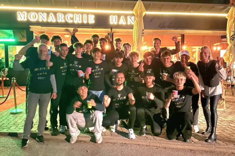 Ein Fußballteam feiert vor einem Lokal.