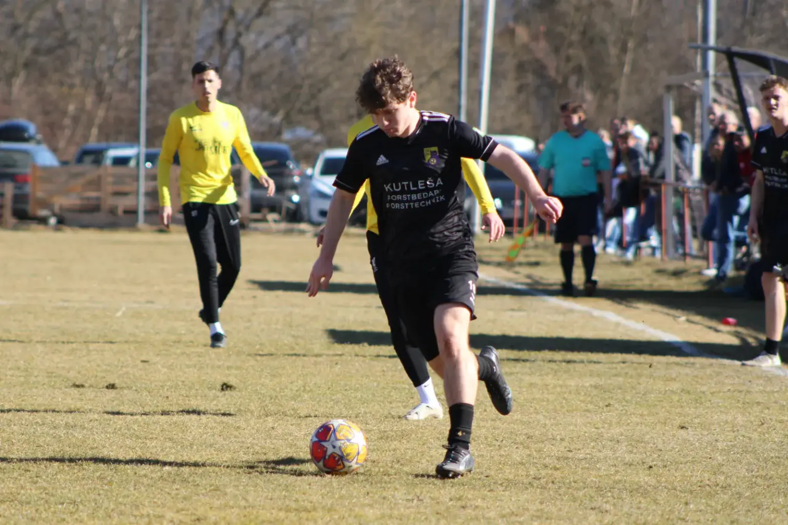 Ein Fußballer läuft einem Ball nach.