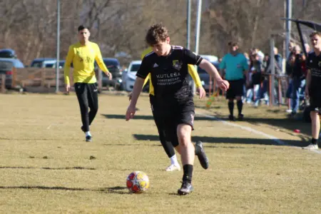 Ein Fußballer läuft einem Ball nach.