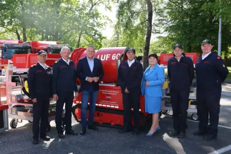 Mehrere Menschen vor Geräten einer Feuerwehr.