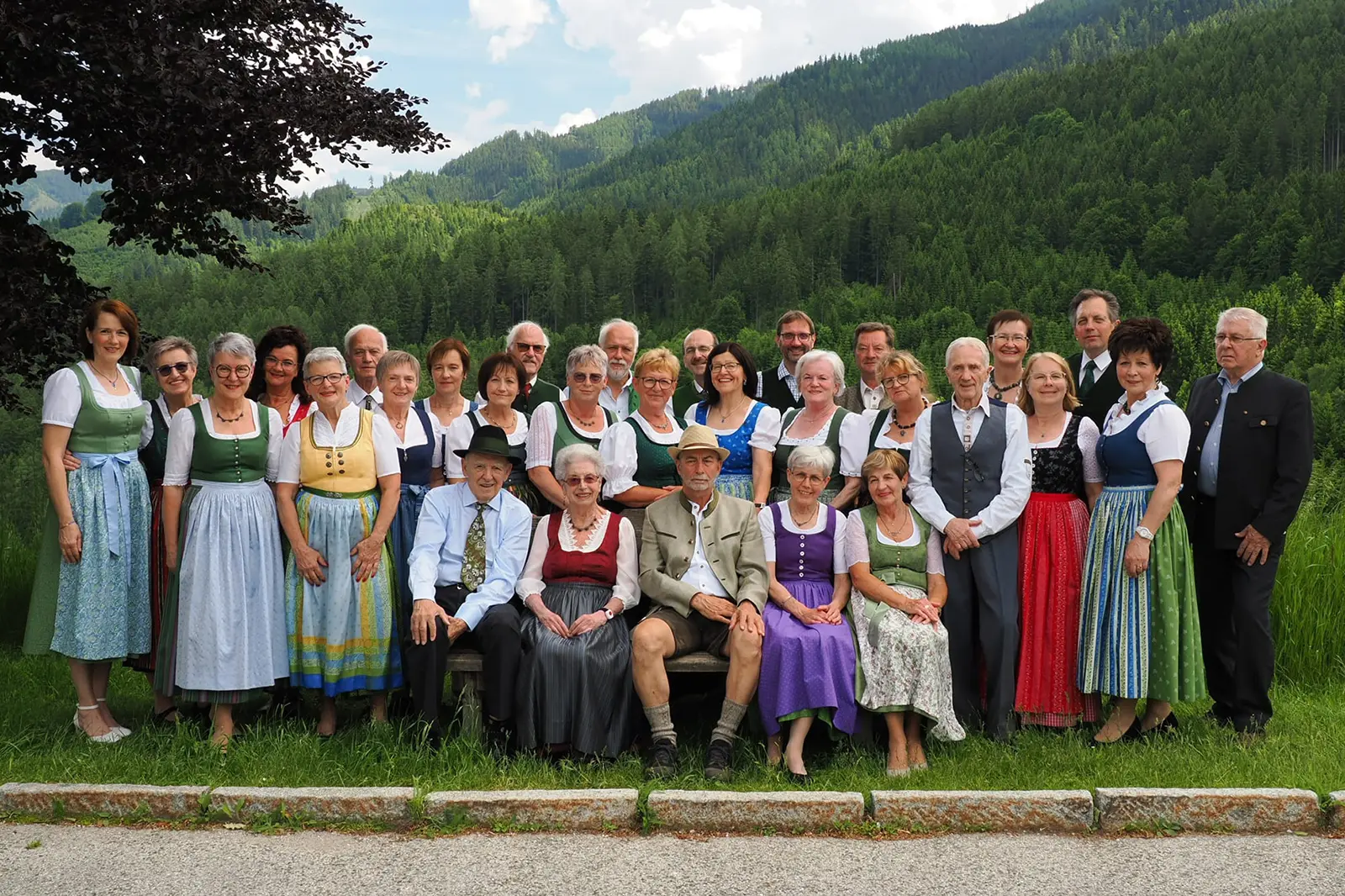 Eine Gruppe von Personen in Tracht steht auf einer Wiese